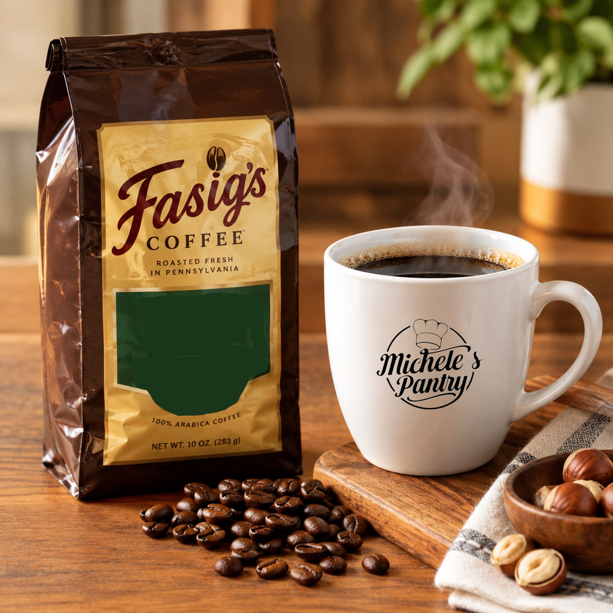 A bag of Fasig's Coffee stands on a wooden table beside a white ceramic mug printed with 'Michele's Pantry,' with coffee beans scattered in front and a small bowl of nuts nearby. The scene is warmly lit and styled as a product listing photo.