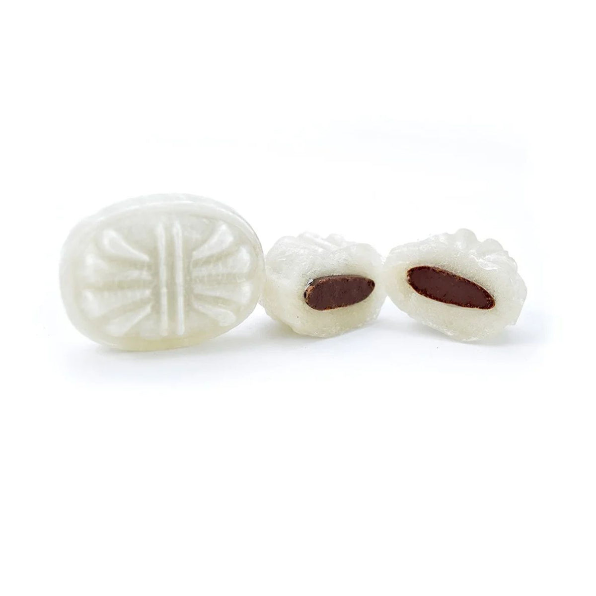 Three white, embossed jelly candies on a plain white background, with two of them cut open to show a dark brown center.
